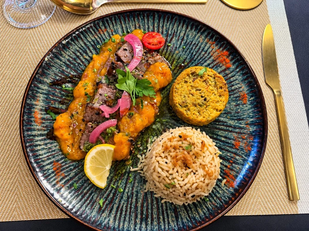 Viande tranchée, sauce fruitée, riz pilaf et pavé de légumes