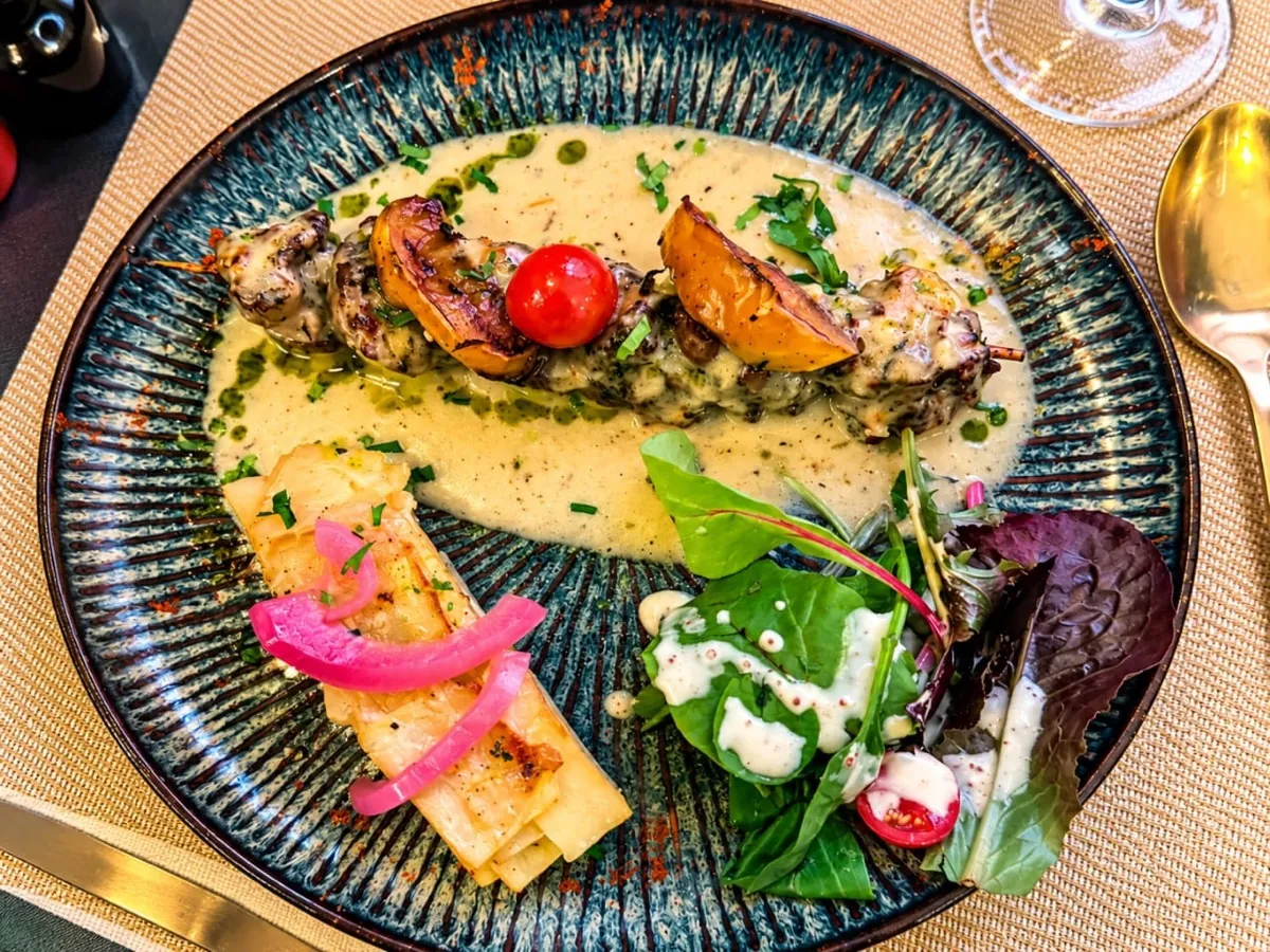 Volaille nappée d'une sauce crémeuse, légumes rôtis et salade