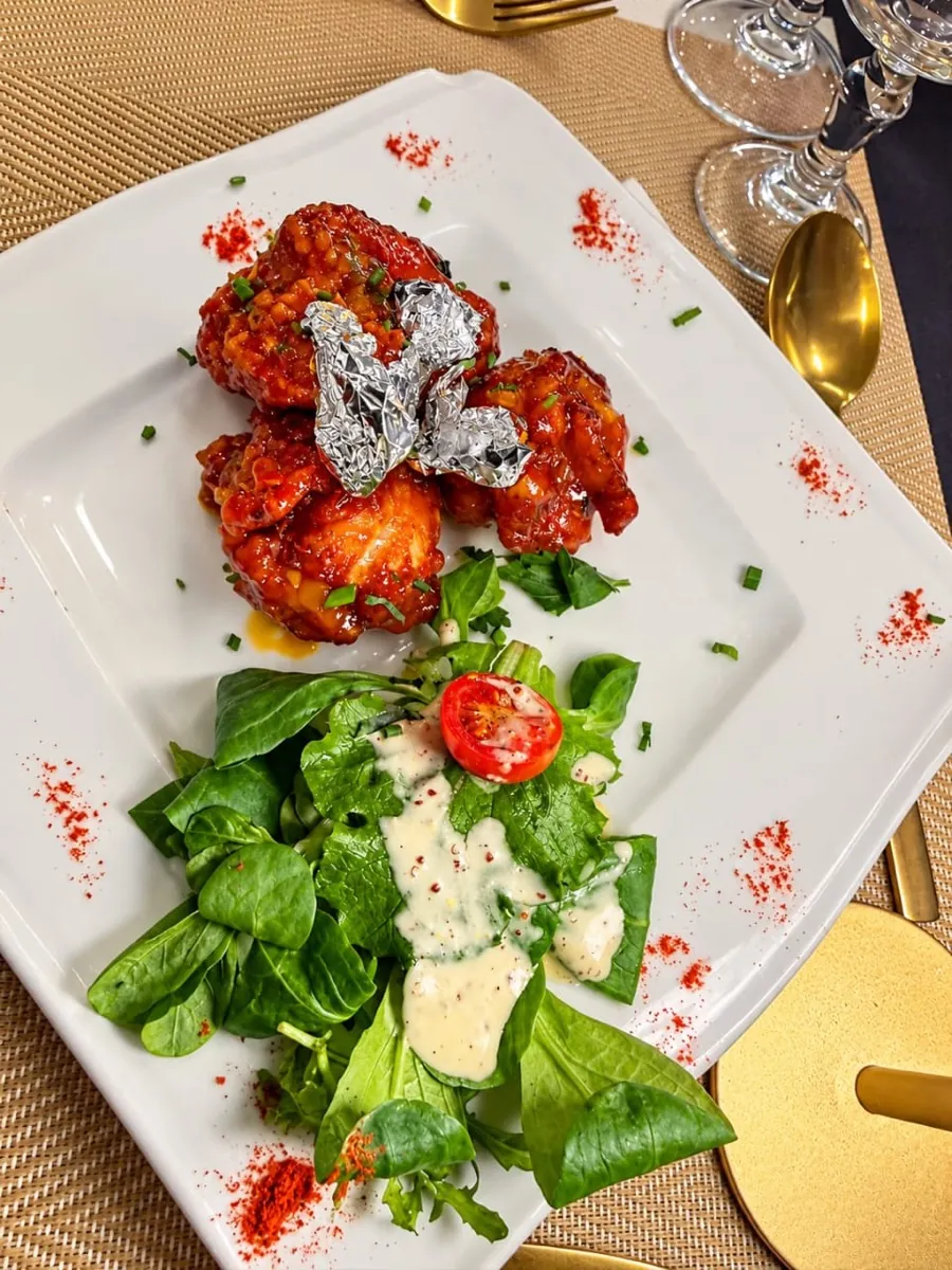 Pilons de poulet marinés aux épices, frits et croustillants, servis avec une salade