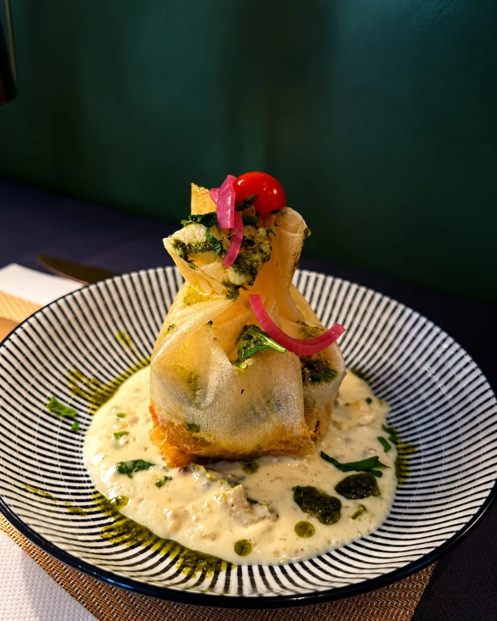 Aumônière croustillante servie dans une sauce crémeuse aux herbes